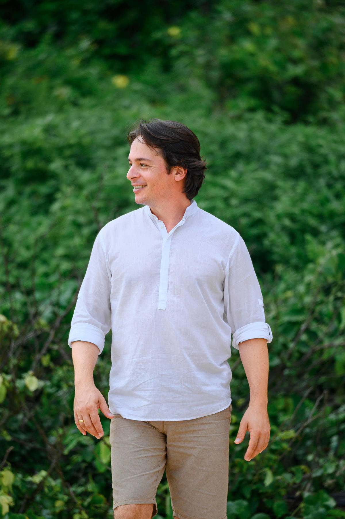 Retrato do noivo durante ensaio pré-wedding na praia em Balneário Camboriú com vegetação ao fundo