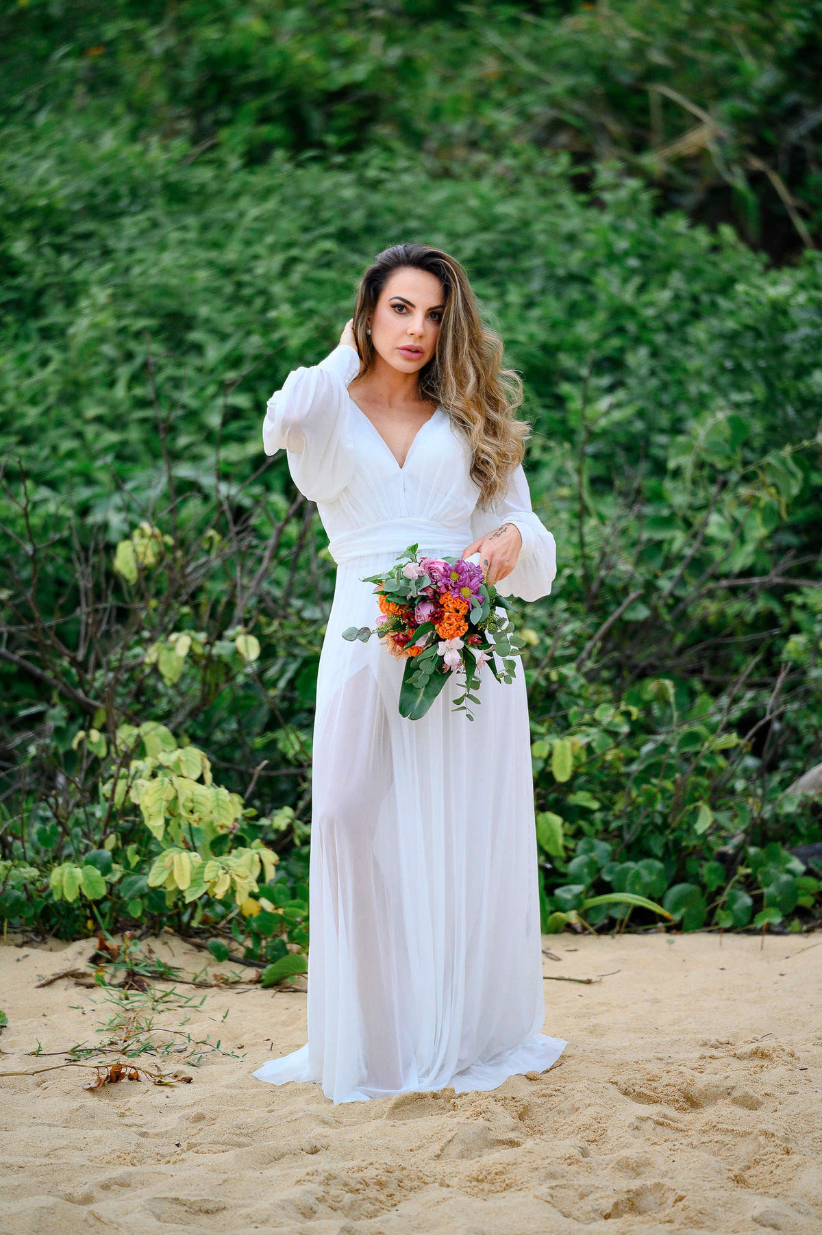 Retrato da noiva durante ensaio pré-wedding na praia em Balneário Camboriú com vegetação ao fundo