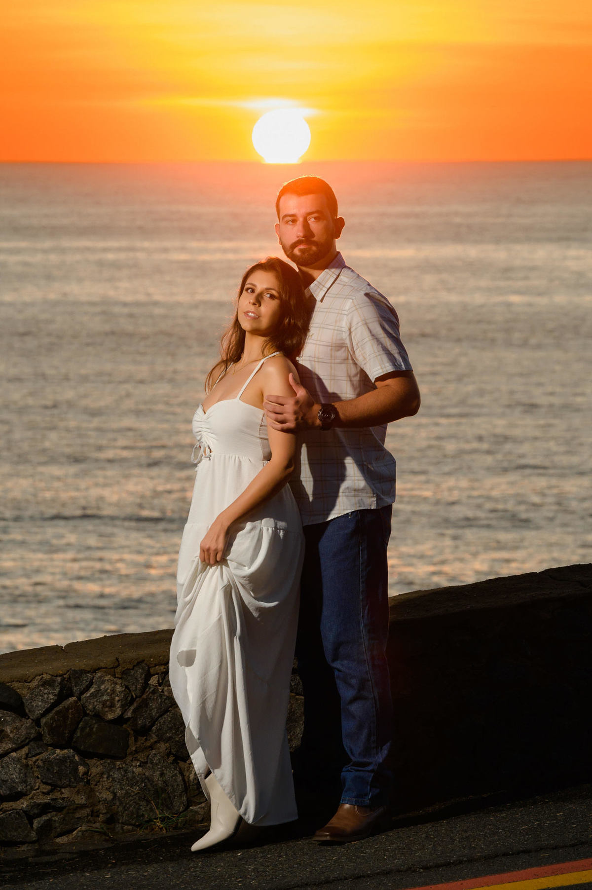 Casal abraçado com o mar ao fundo e luz suave do amanhecer na Praia de Taquarinhas, Balneário Camboriú, durante ensaio pré-wedding