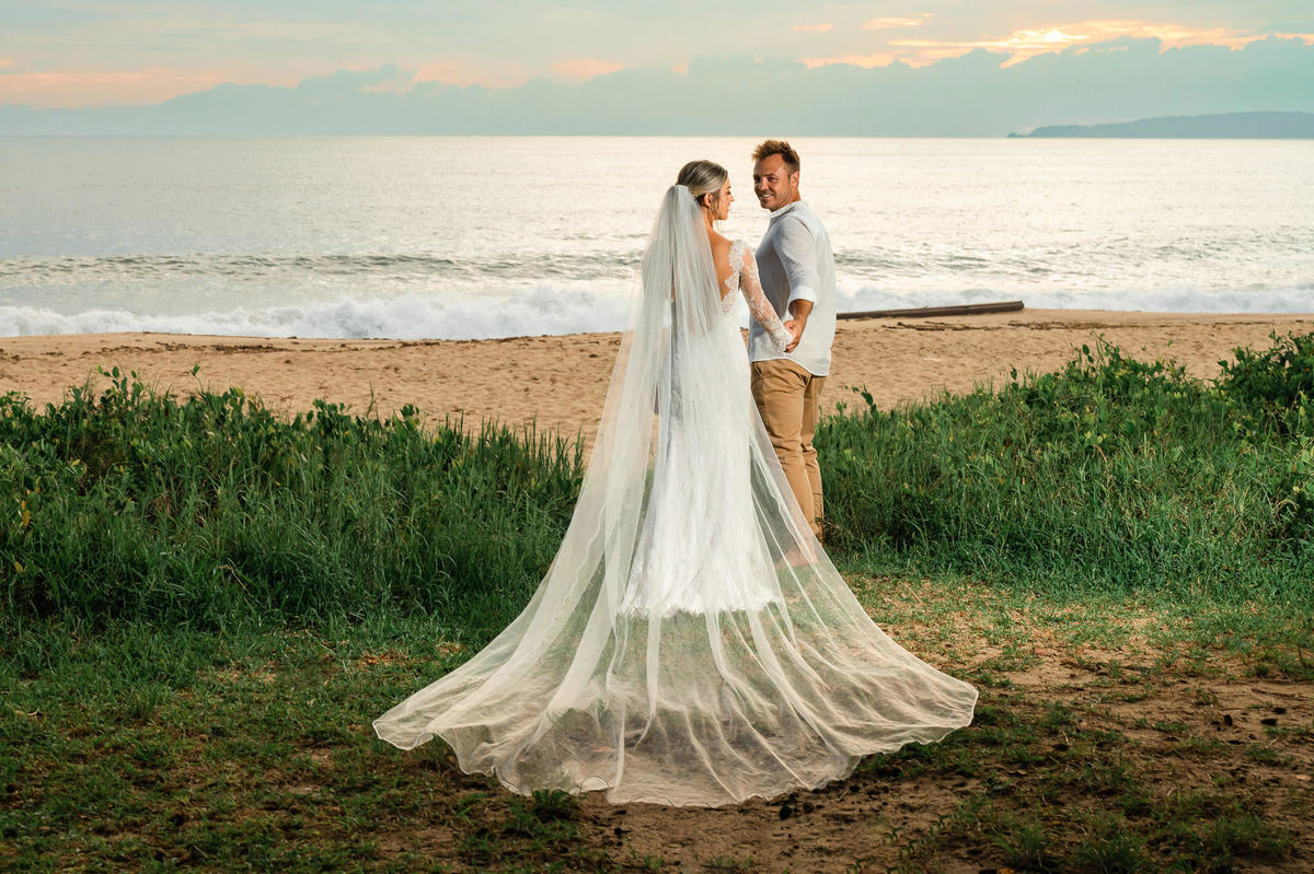 Ensaio pré-wedding na praia em Itapema SC ao amanhecer, com casal em frente ao mar e céu com tons suaves do início do dia.