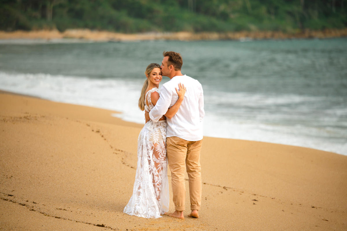 Fotografia de casal durante ensaio pré-casamento na Praia Grossa, Itapema, com costões e natureza preservada