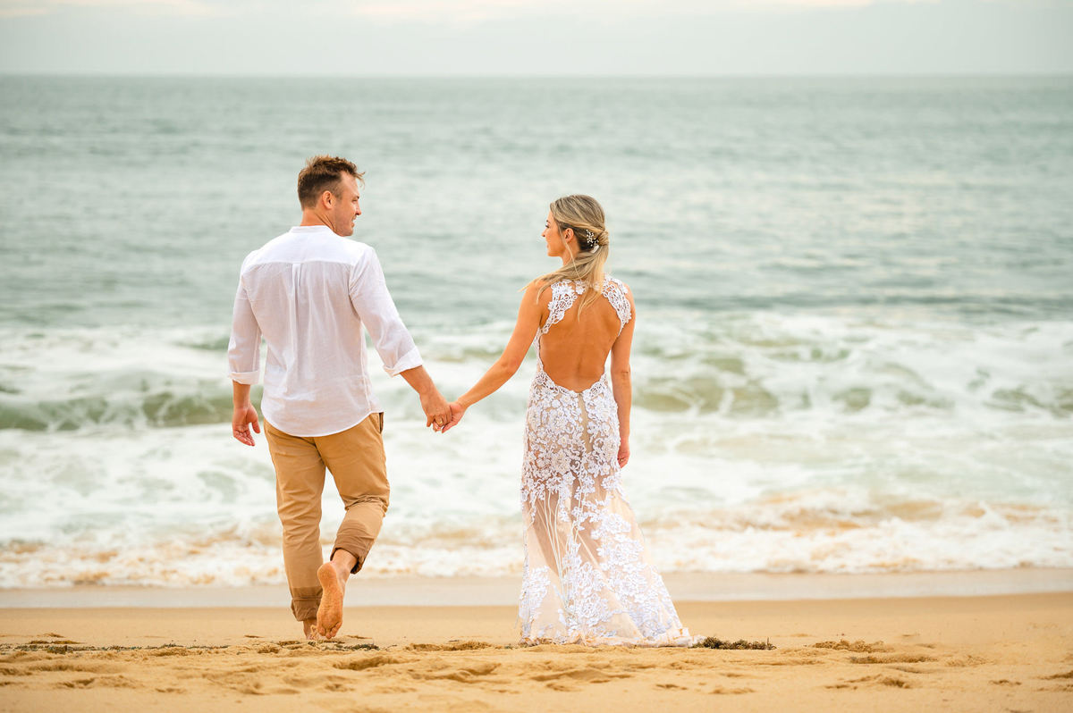 Casal caminhando na Praia Grossa em ensaio pré-wedding em Itapema, Santa Catarina