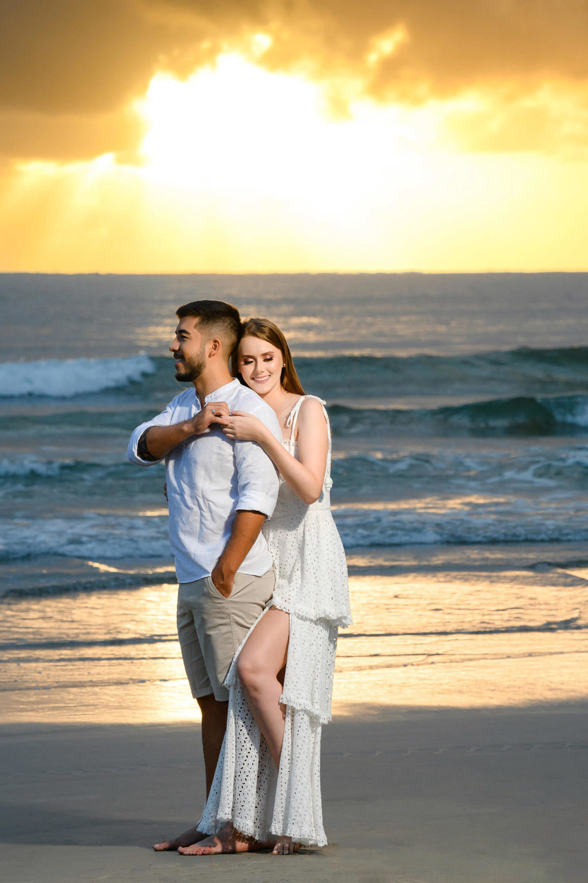 Close do casal se abraçando na beira da água durante ensaio pré-wedding ao amanhecer em Bombinhas, Santa Catarina