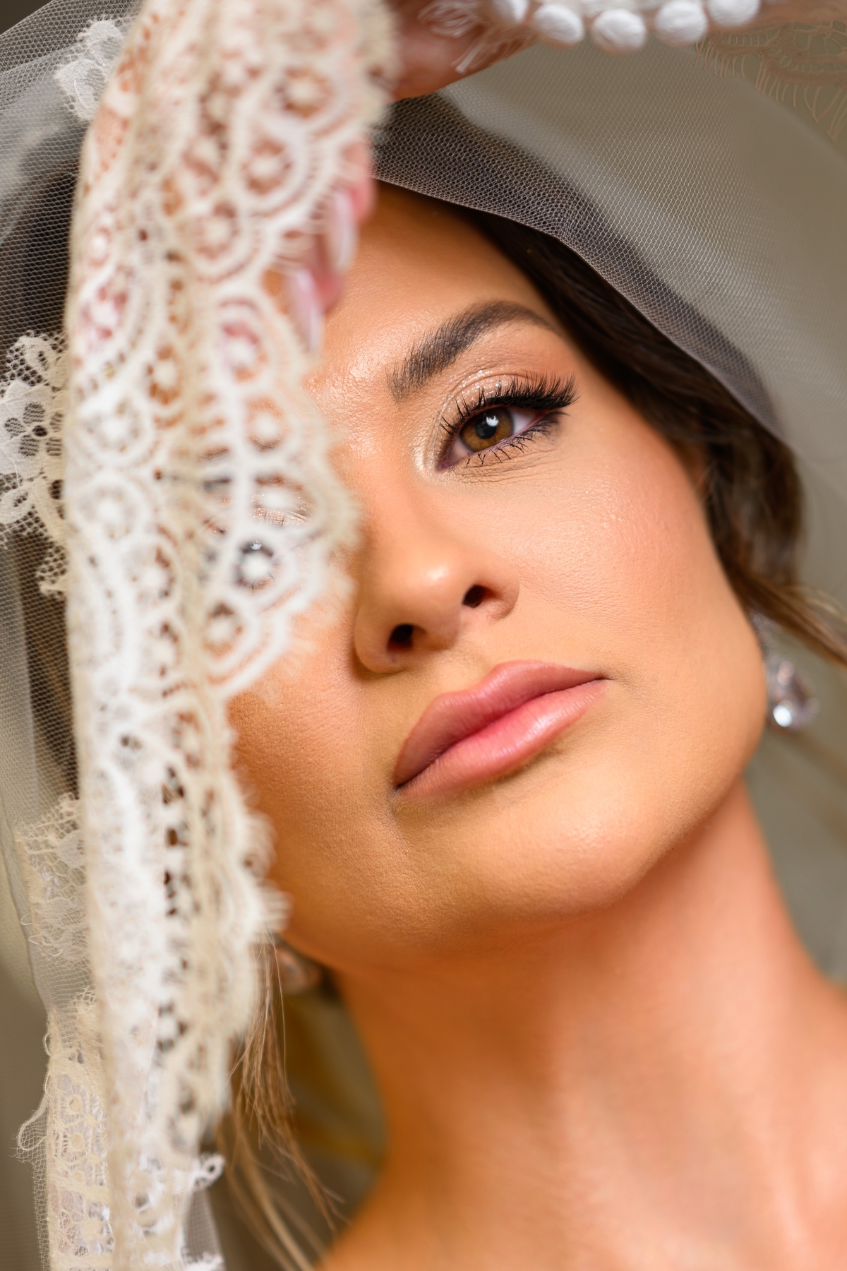 Retrato fechado da noiva com véu e renda durante o making of