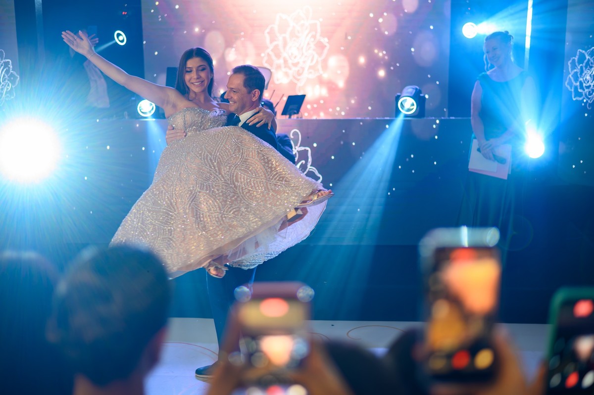 Debutante celebrando com o pai durante um momento marcante da festa.