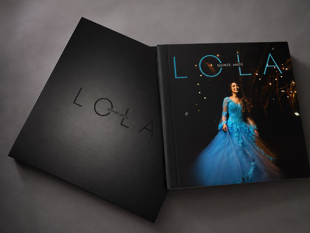 Álbum fotográfico de festa de 15 anos aberto com fotografias da debutante.