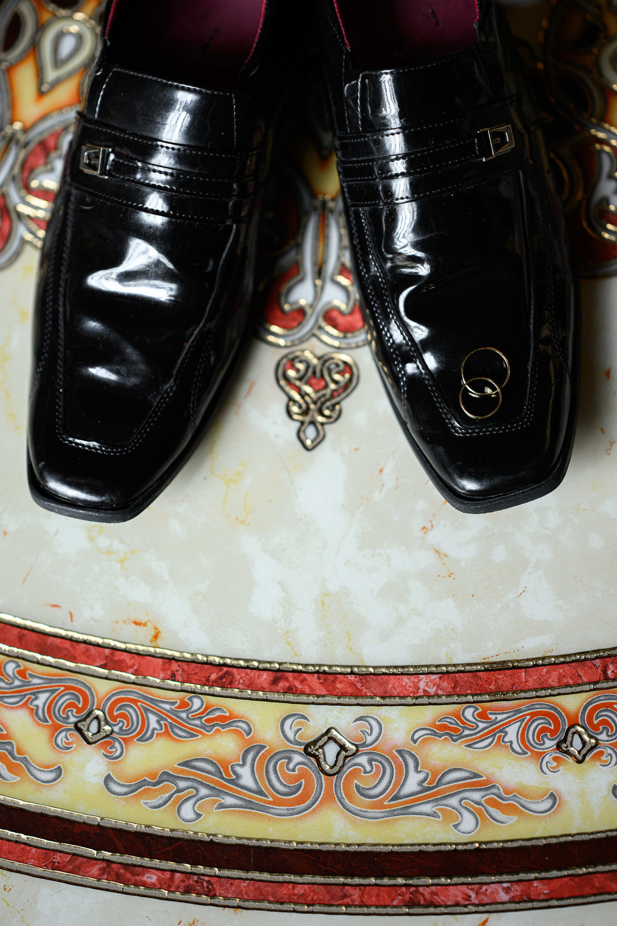 Fotografia dos sapatos do noivo e alianças de casamento no Palazzo Canello em Itajaí