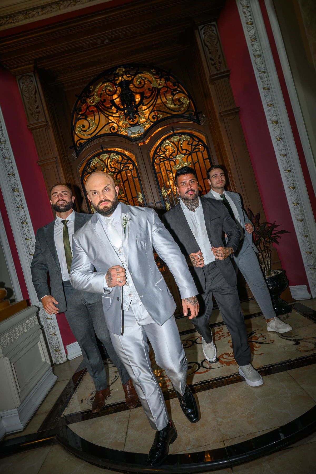 Fotografia do noivo com amigos diante da porta do Palazzo Canello em Itajaí
