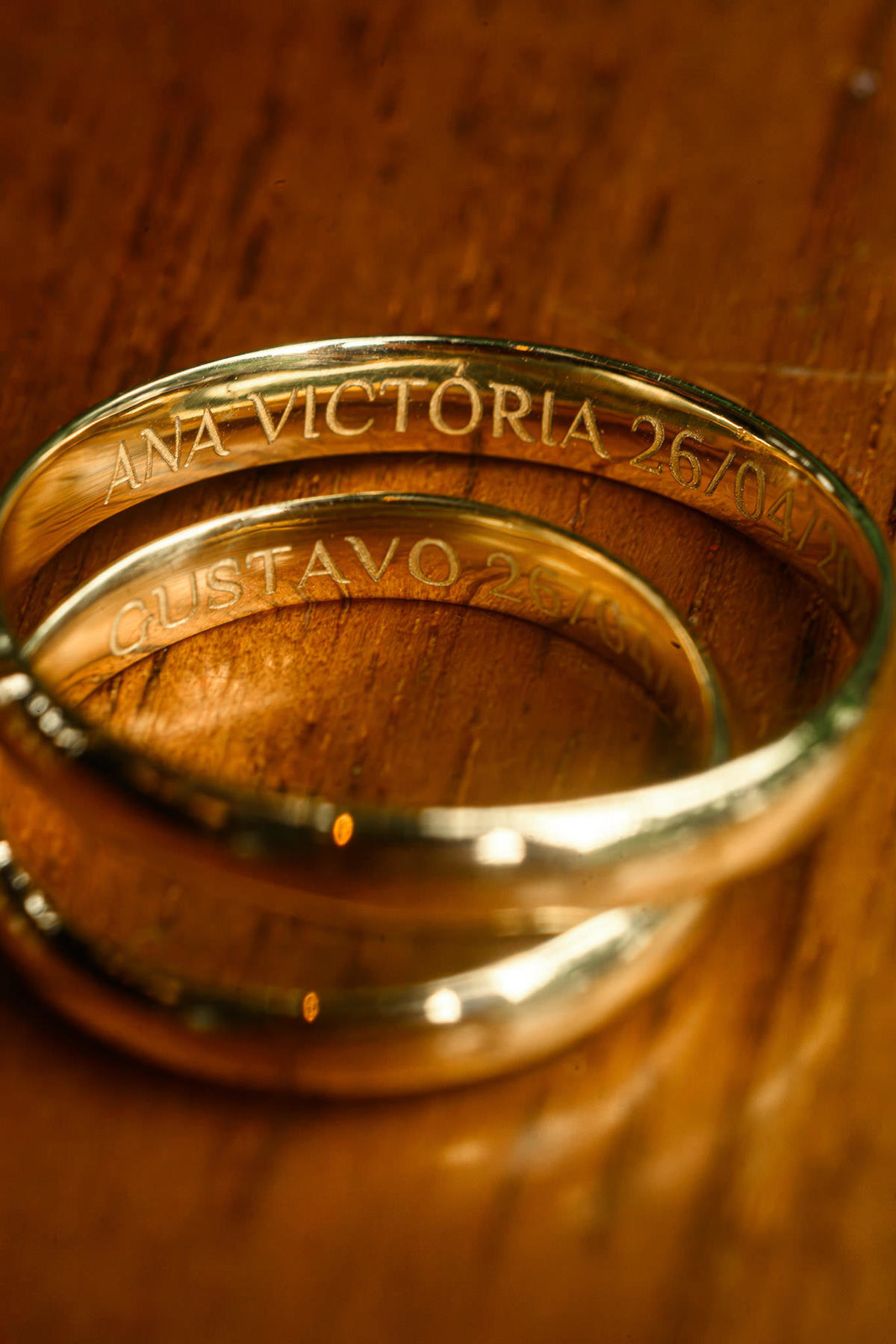 Alianças de casamento gravadas com os nomes do casal e a data da cerimônia.