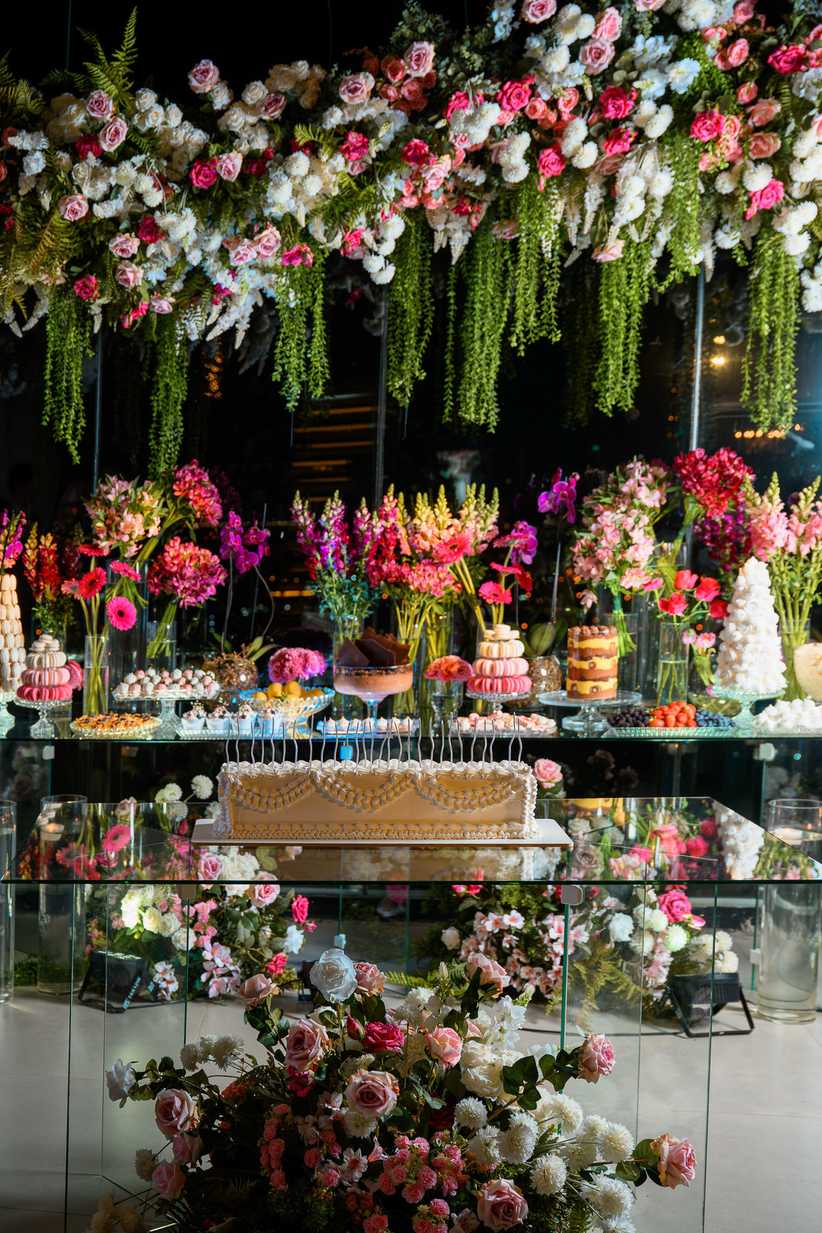 Mesa de doces com flores coloridas no Indaiá Eventos
