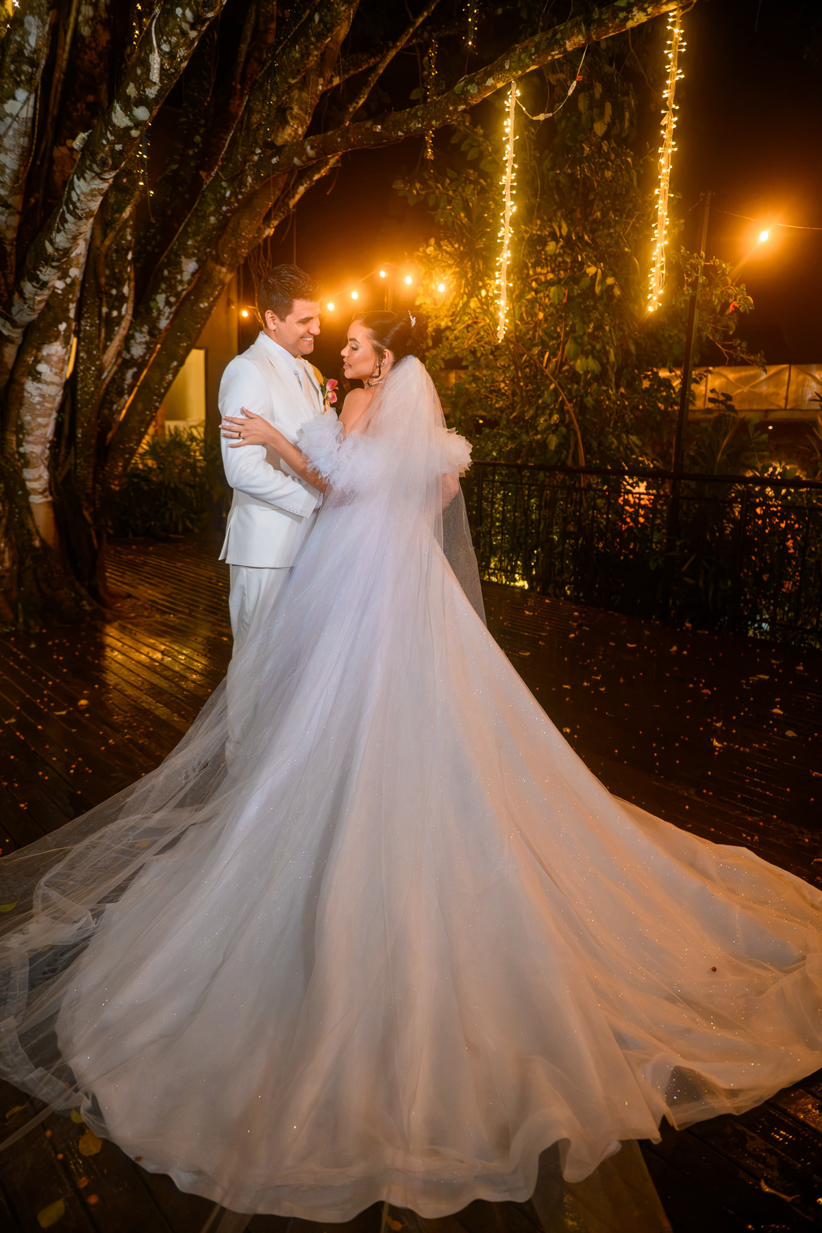 Noiva e noivo sob luzes no jardim do Indaiá Eventos