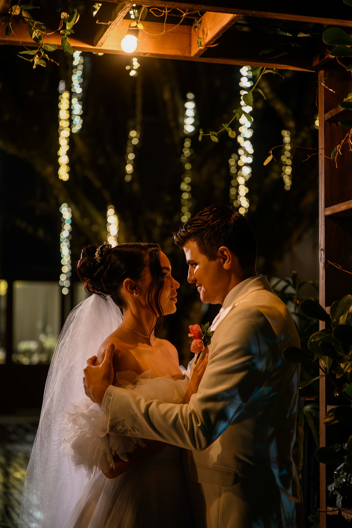 Casal em retrato intimista entre folhagens iluminadas