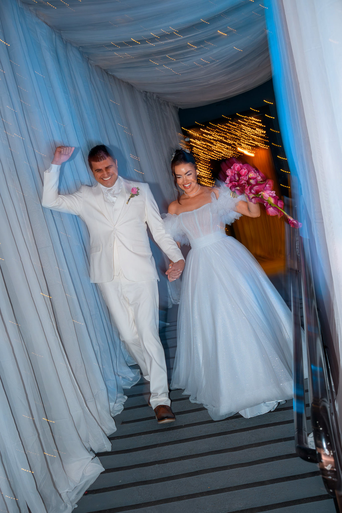 Noiva e noivo chegando à recepção do casamento