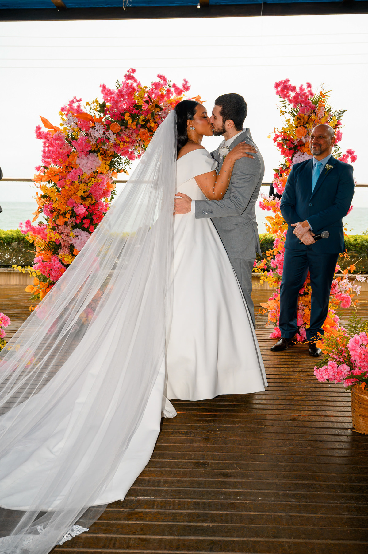 Noivos se aproximando para o beijo diante do altar floral