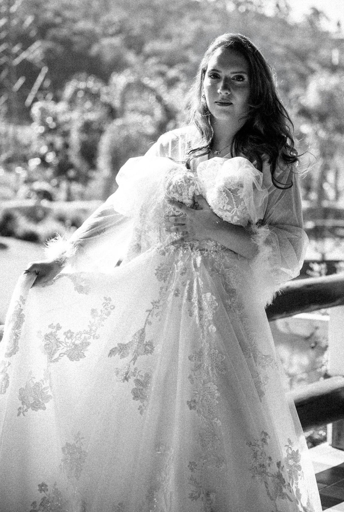 Noiva em preto e branco segurando o vestido de casamento