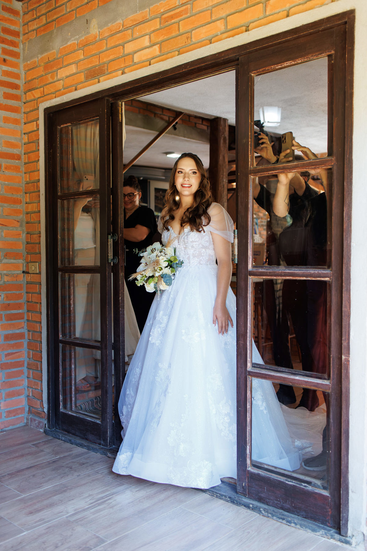 Noiva pronta saindo pela porta para seguir à cerimônia
