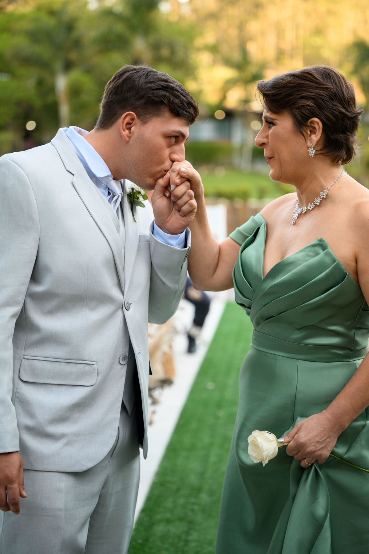 Noivo beijando a mão da mãe durante a entrada