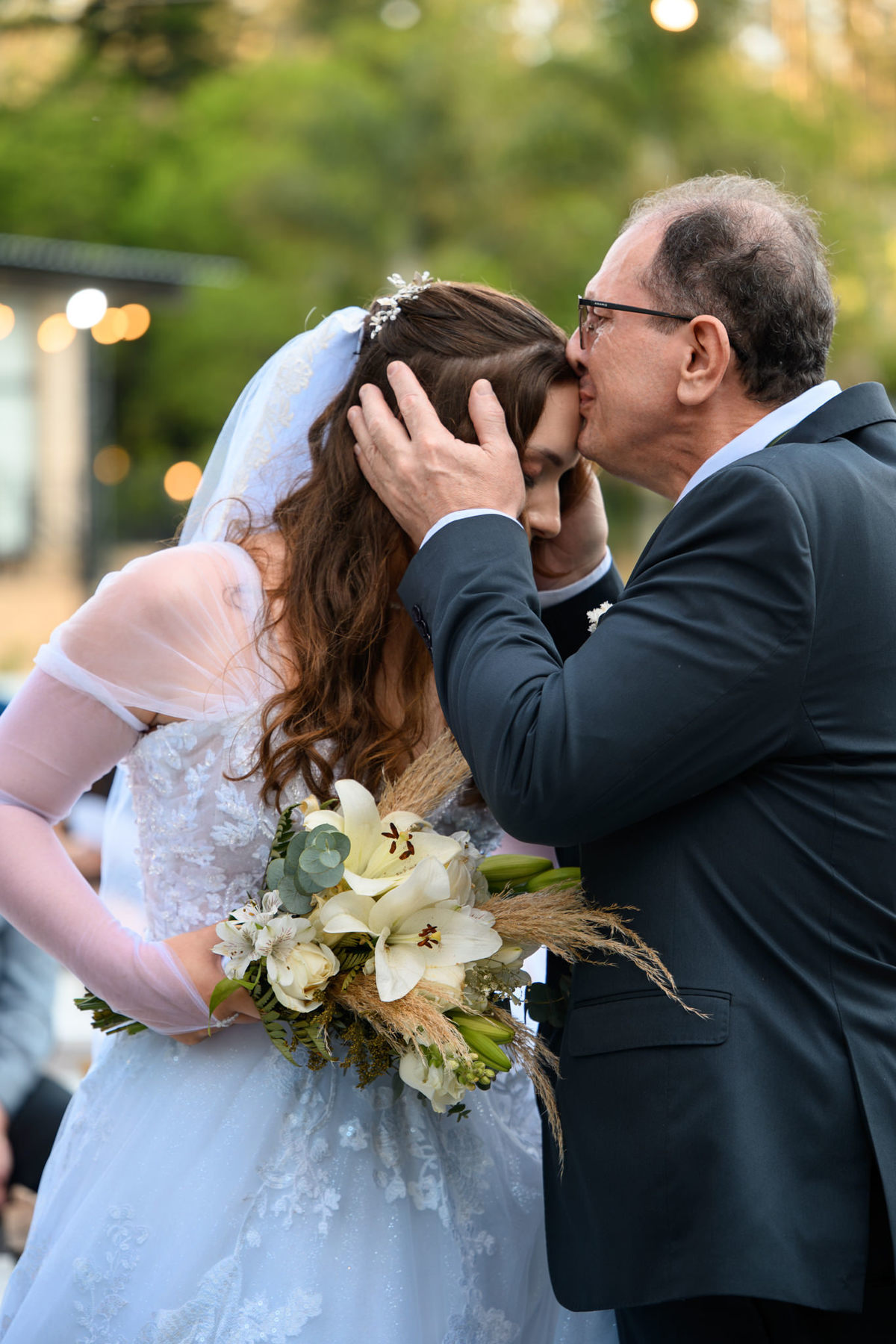 Close do pai beijando a noiva antes da entrega