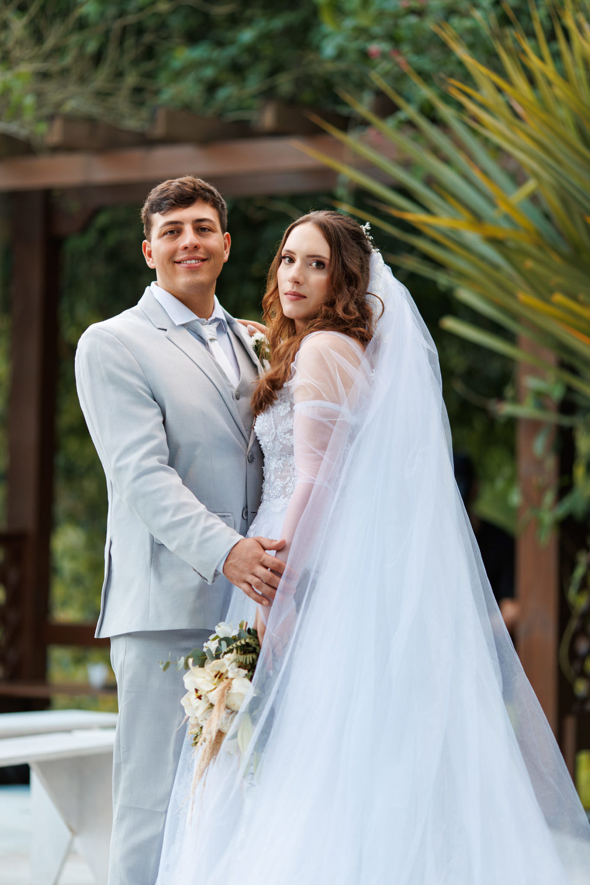 Retrato do casal após a cerimônia com vegetação ao fundo