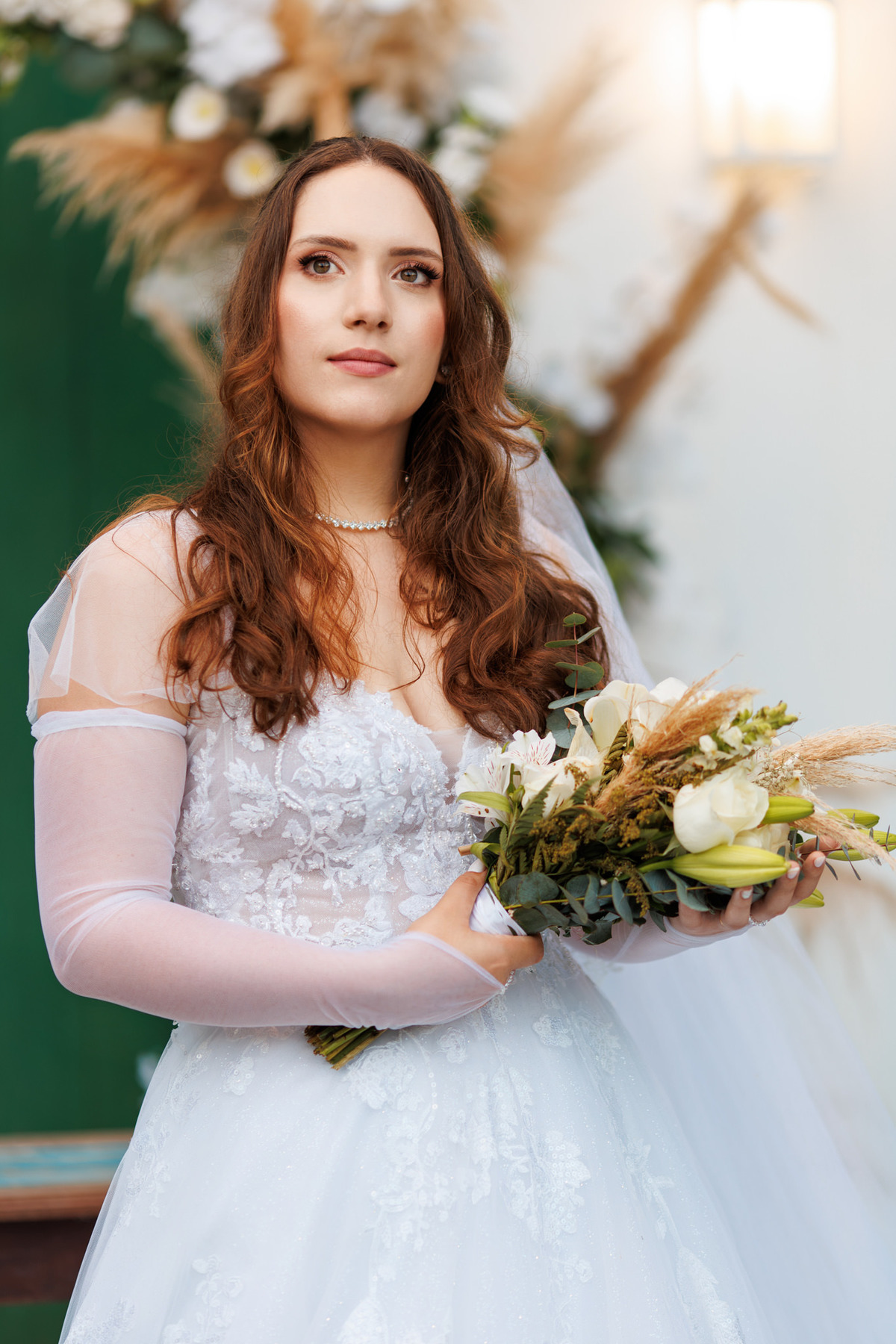 Retrato da noiva com buquê diante da decoração floral