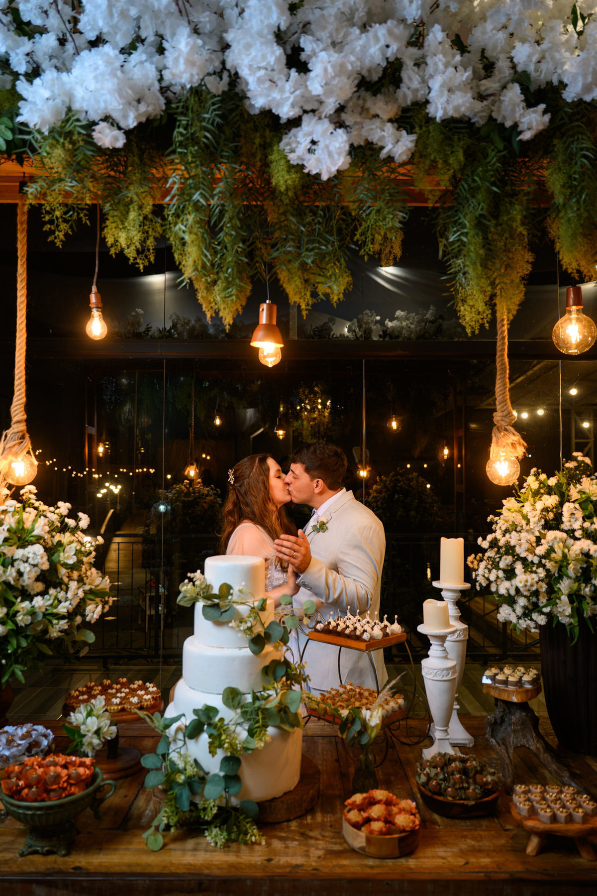  Casal se beijando na mesa de doces decorada com flores