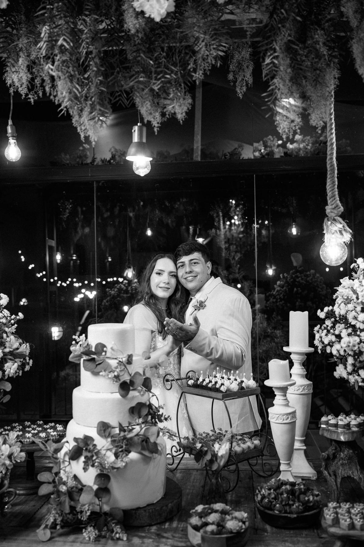 Retrato em preto e branco do casal junto ao bolo
