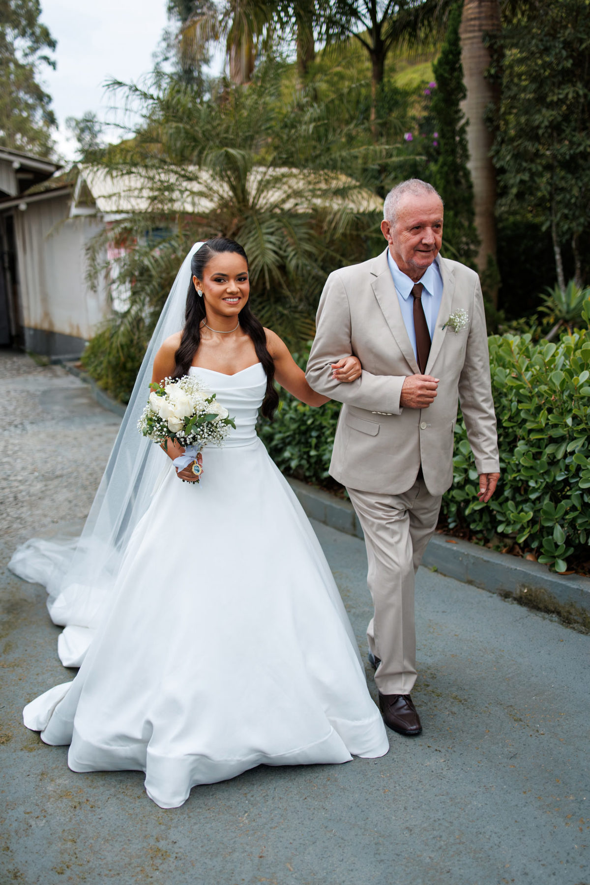 Noiva caminhando com o pai antes da entrada da cerimônia