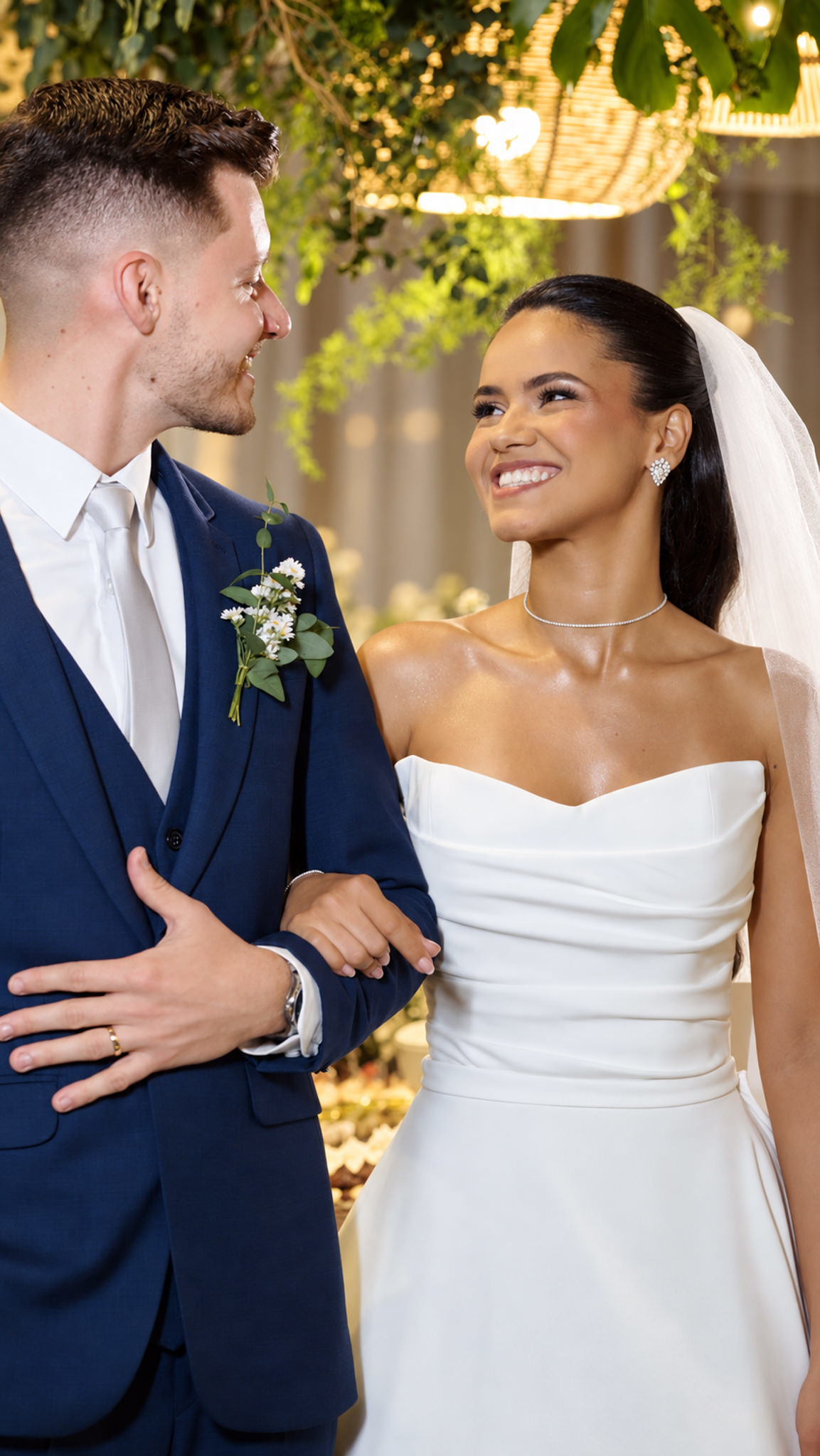 Noivos sorrindo um para o outro durante retrato do casal