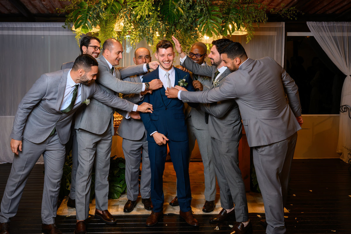 Noivo com padrinhos em fotografia descontraída na recepção