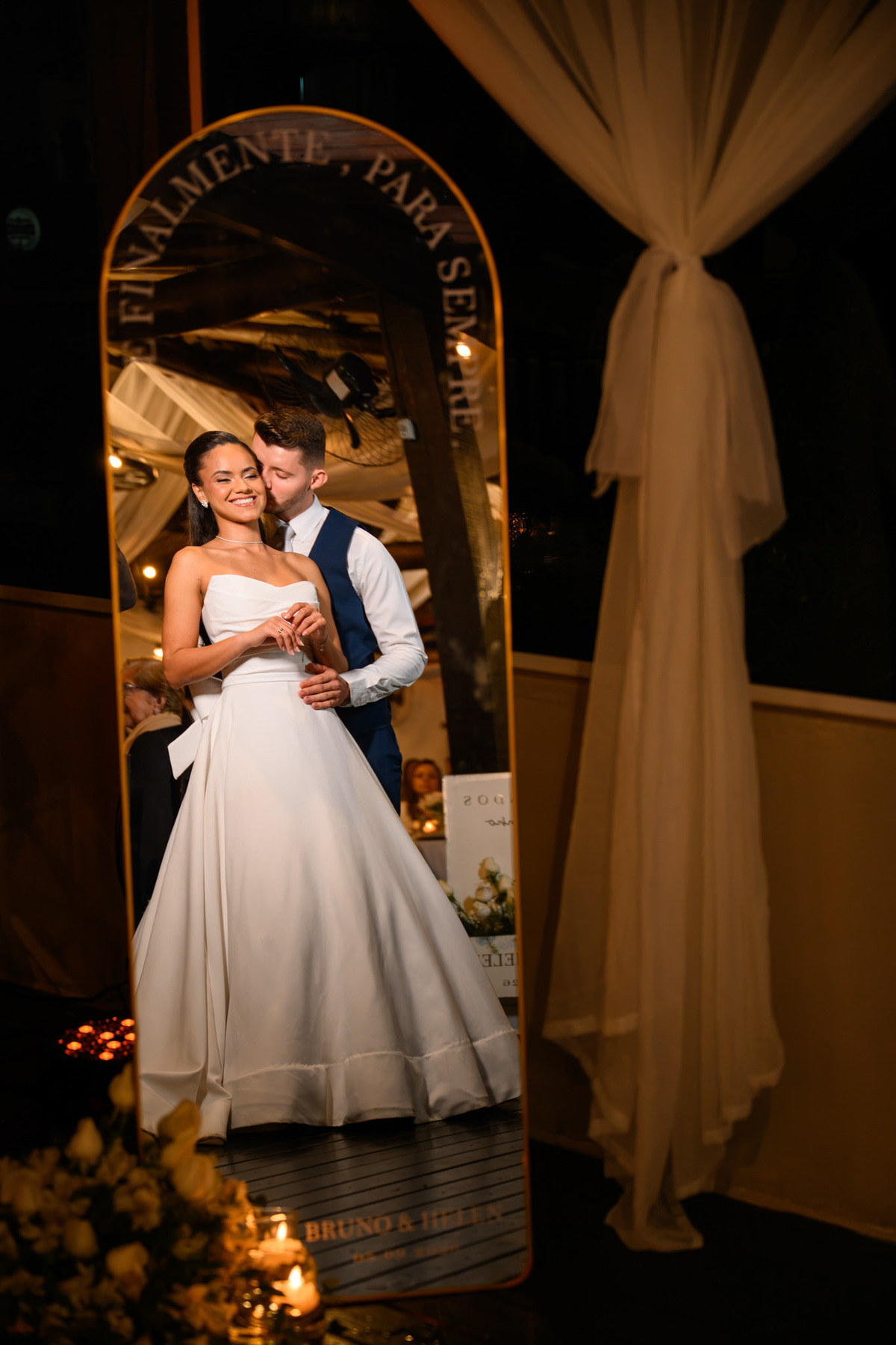 Casal refletido em espelho decorativo durante a recepção