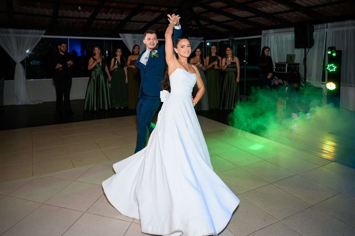 
66. Noivos dançando com iluminação colorida na festa de casamento