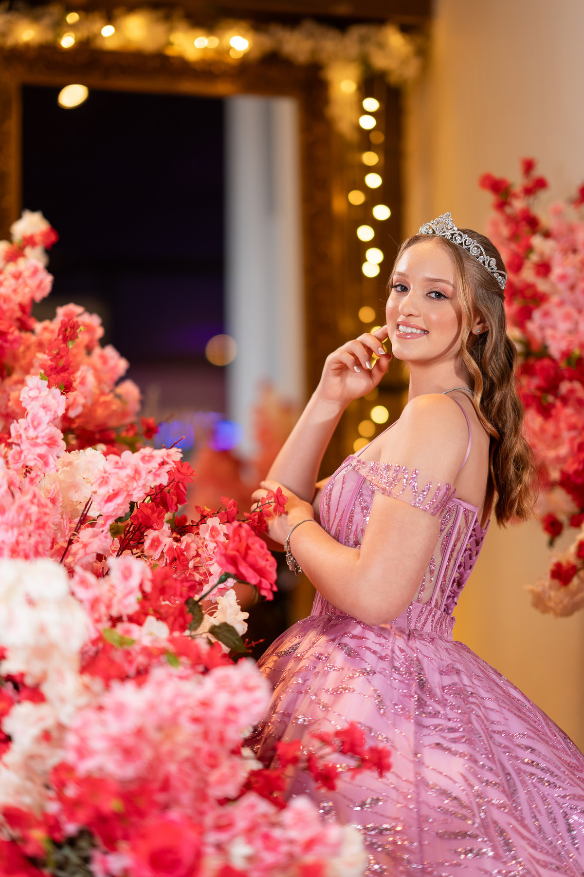 08. Retrato da debutante com vestido rosa entre flores da decoração
