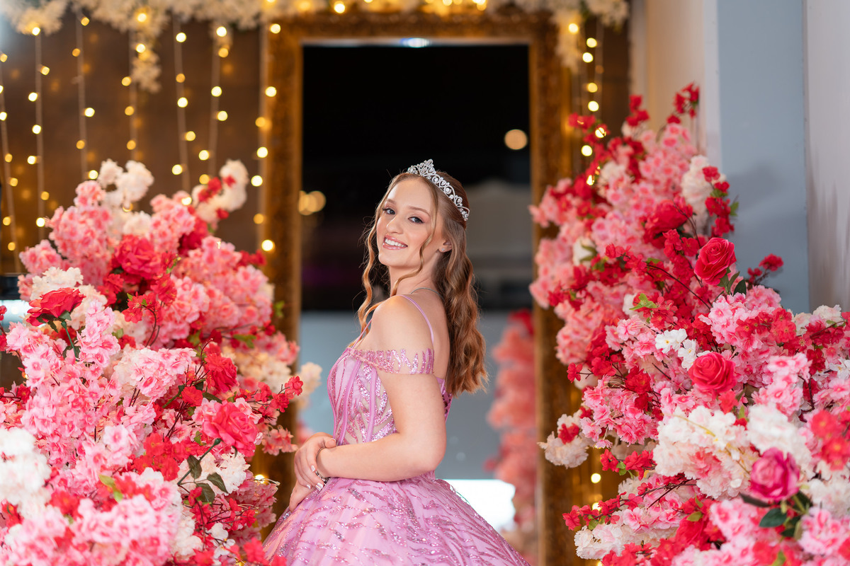 09. Debutante em retrato cercado pela decoração floral rosa
