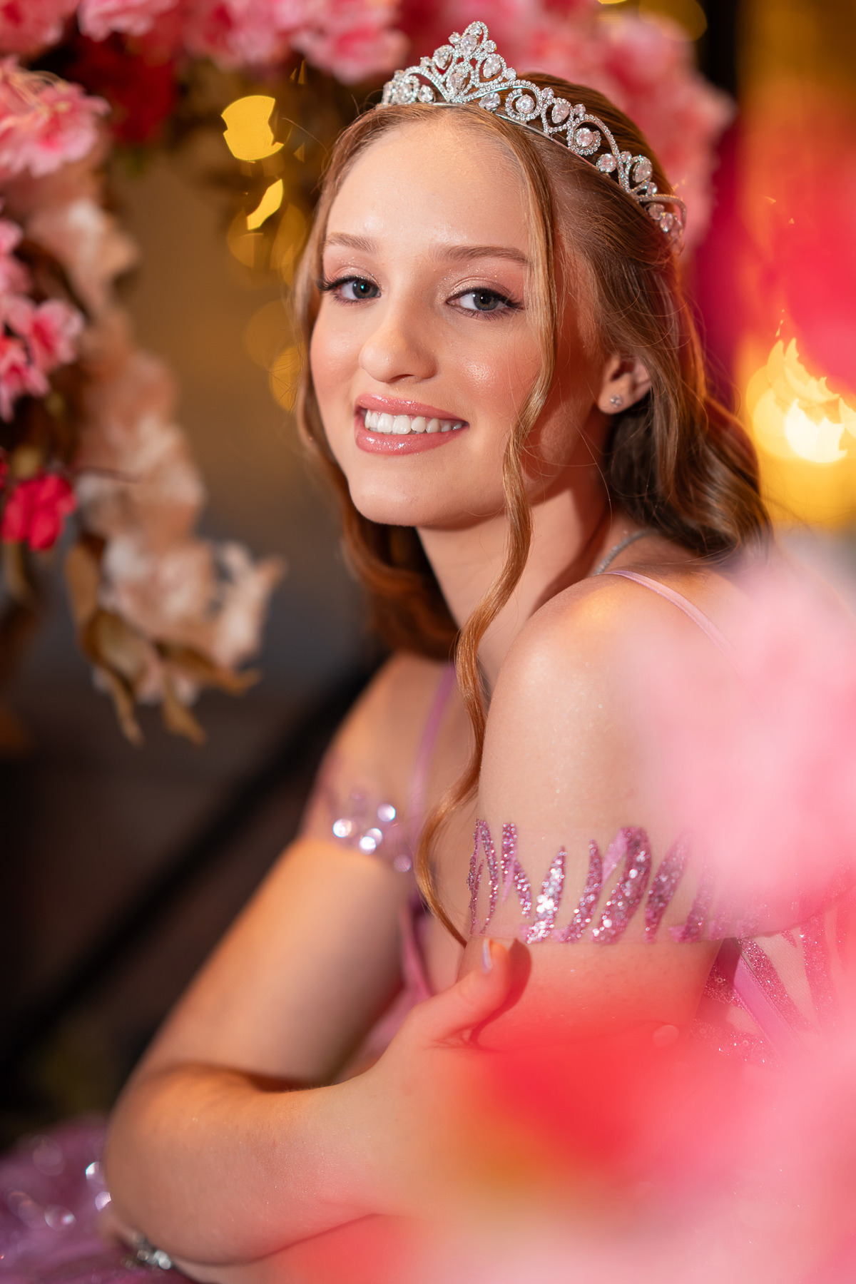 14. Retrato da debutante com flores rosas desfocadas diante da câmera
