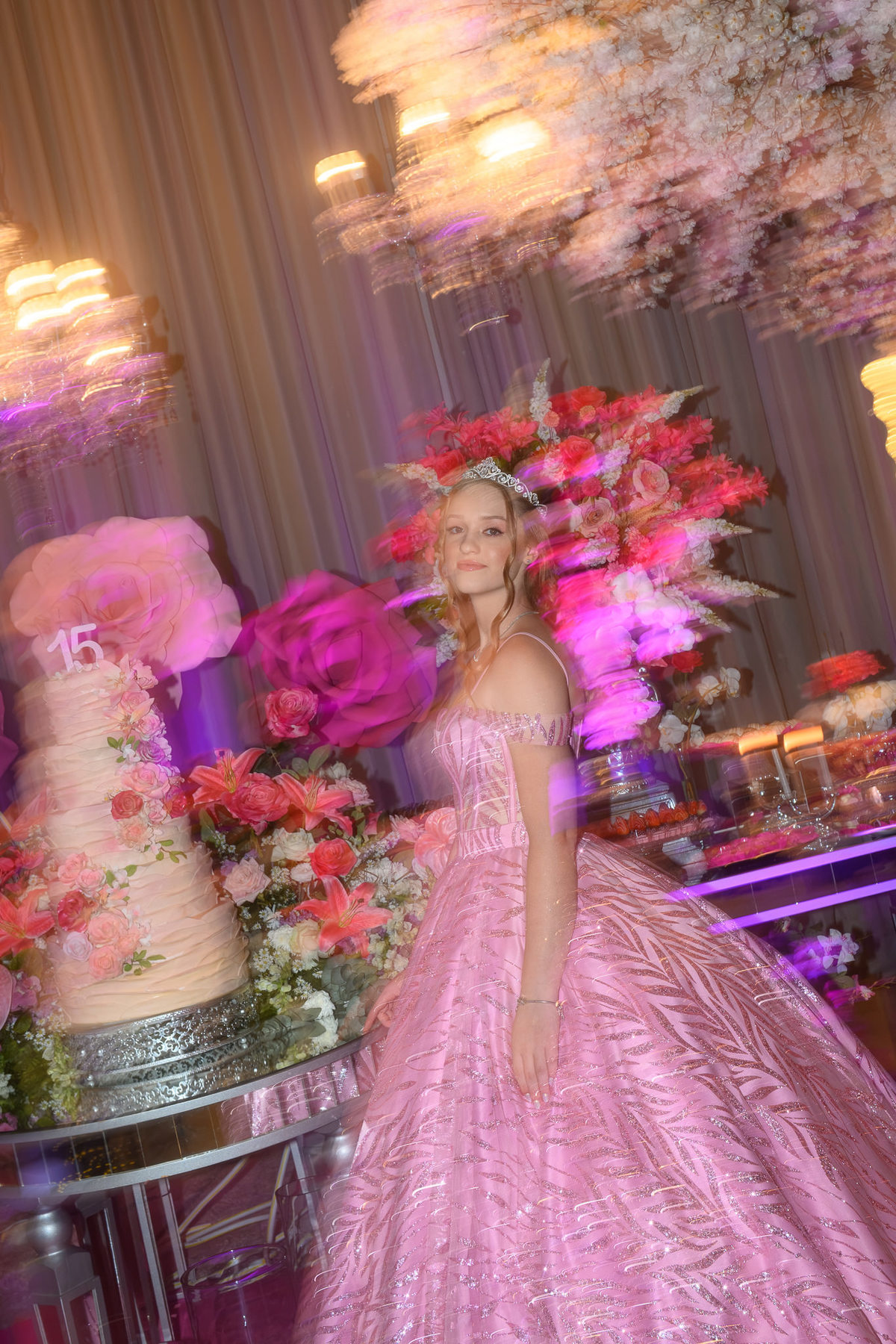 36. Debutante ao lado do bolo em fotografia com arrasto de movimento
