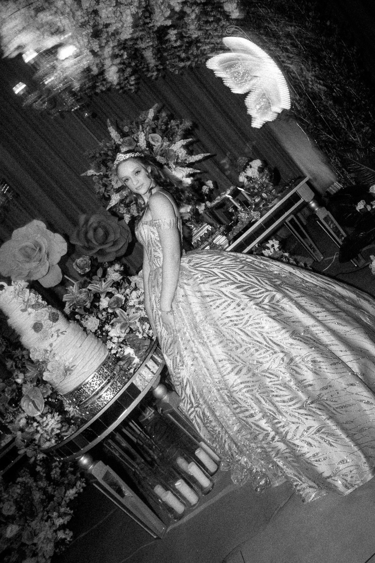 39. Fotografia em preto e branco da debutante junto ao bolo e decoração

