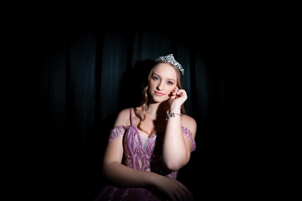 50. Retrato editorial da debutante com iluminação cinematográfica e fundo preto
