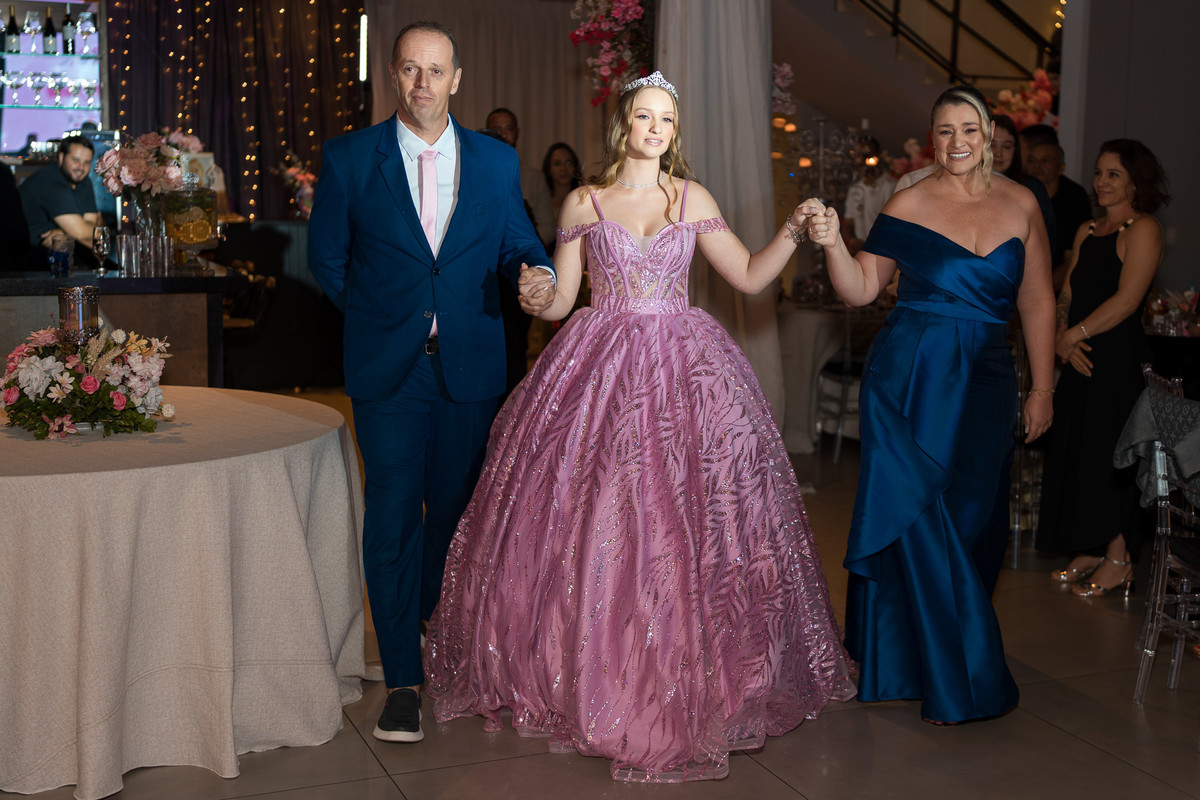 57. Debutante entrando na festa acompanhada pelo pai e pela mãe
