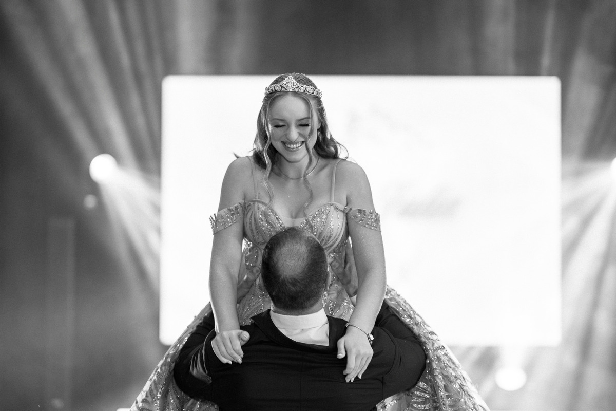 61. Fotografia em preto e branco do pai levantando a debutante durante a dança
