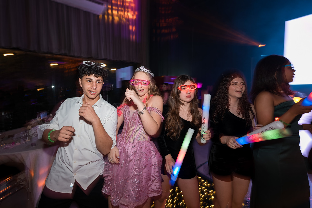 80. Debutante com amigos e bastões luminosos durante a festa
