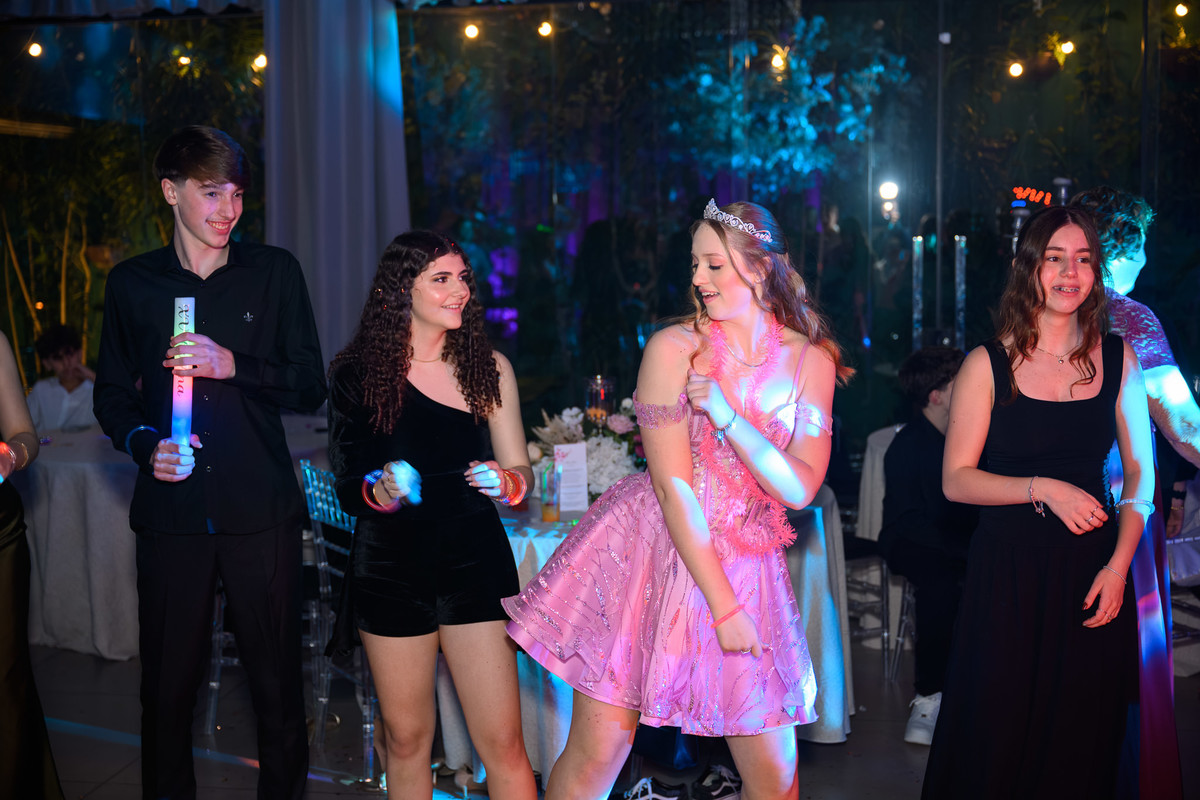 91. Debutante interagindo com robô de LED sob feixes de luz
