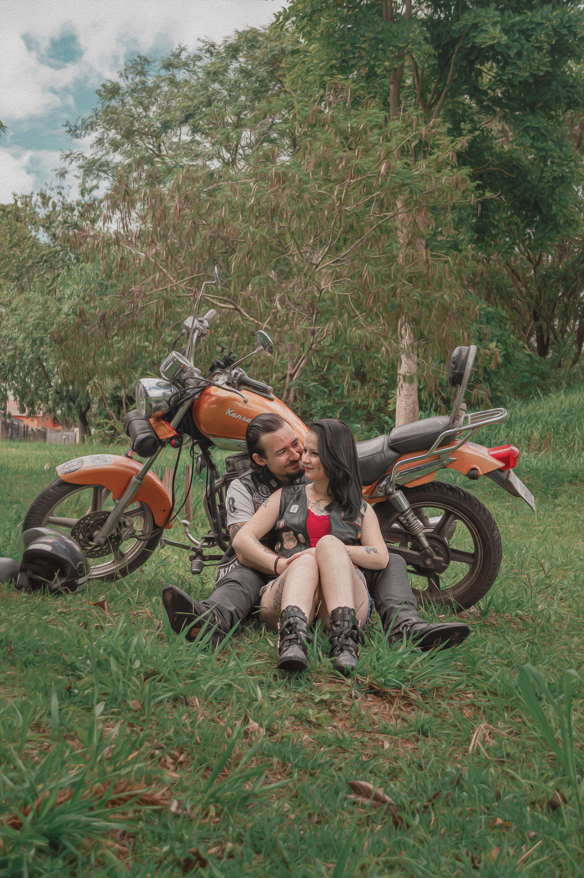 fotografia-casal-sentado-no-chão-moto-ao-fundo