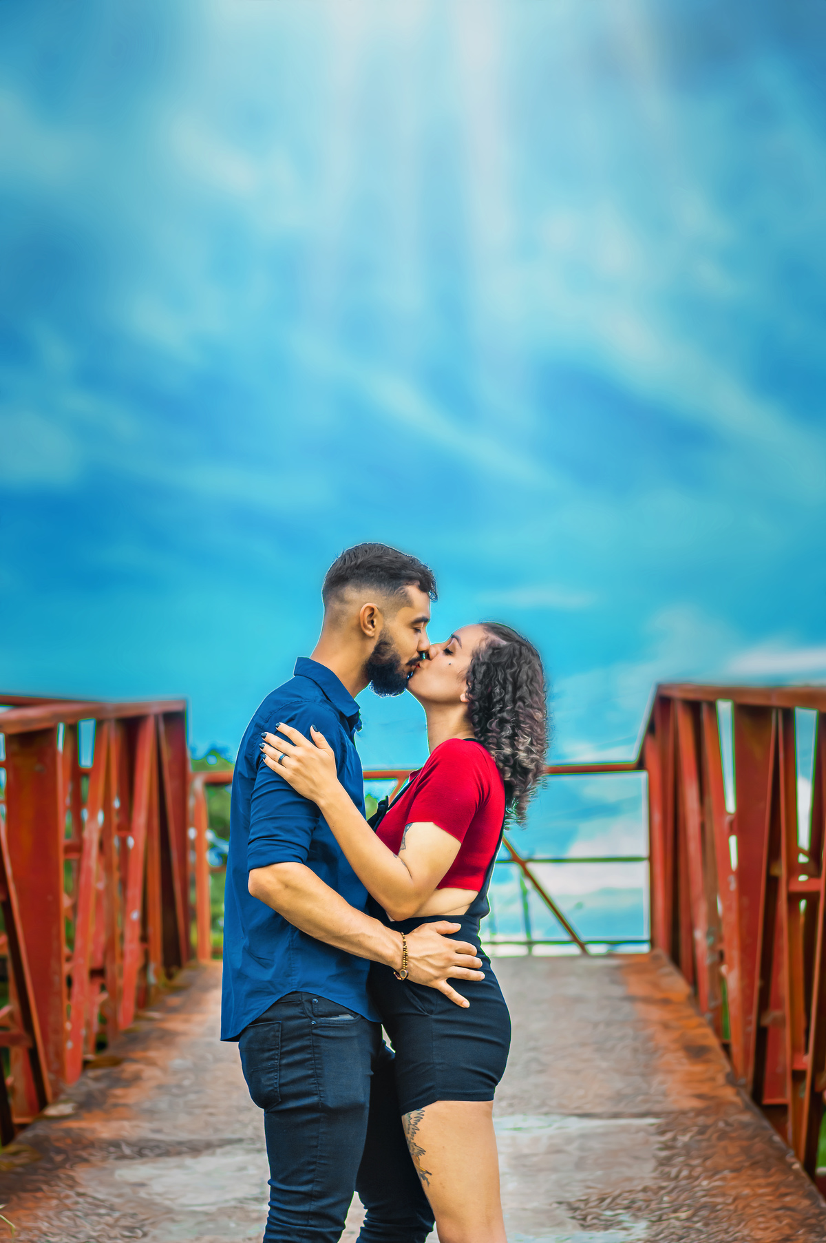 casal-se-beijando-numa-ponte-ceu-azul-de-fundo