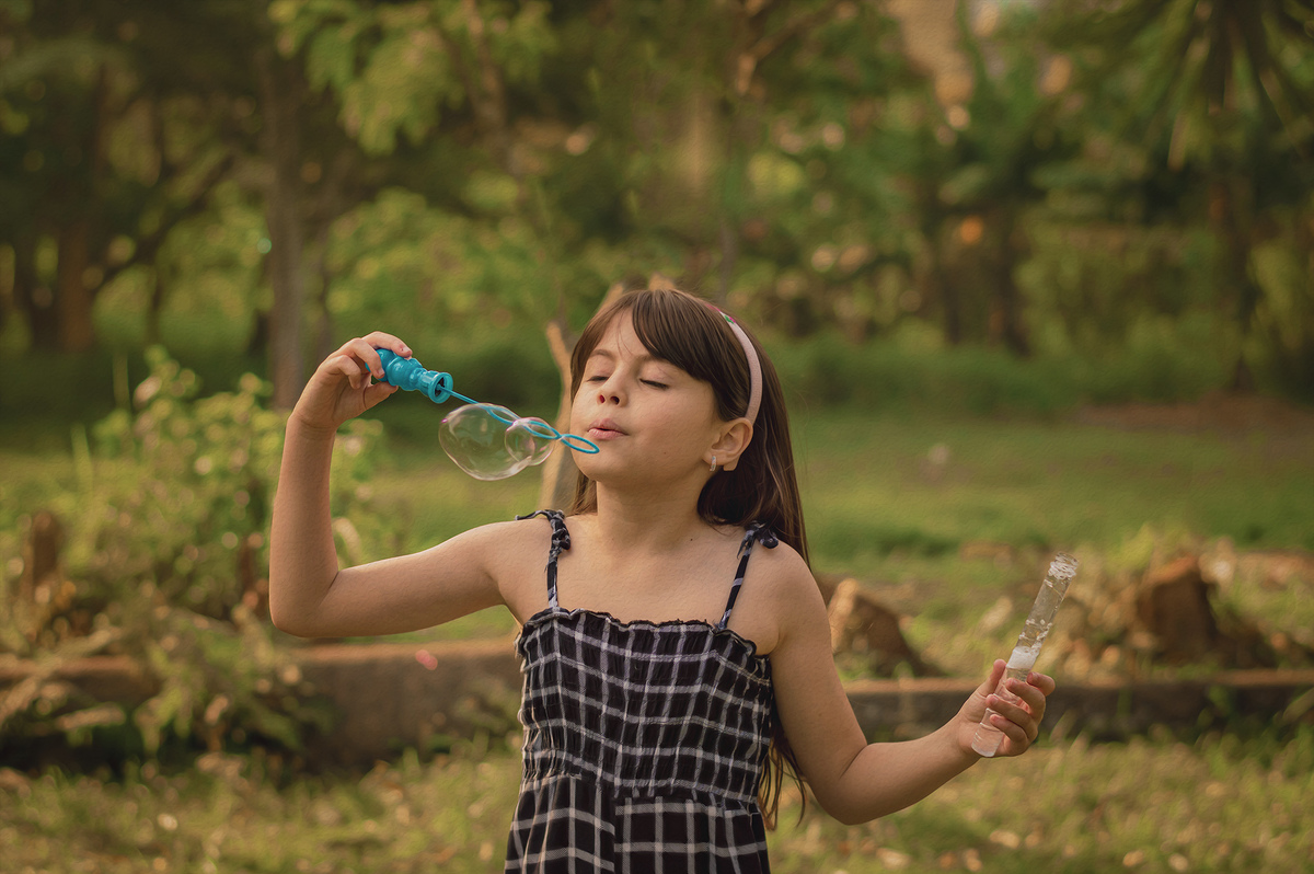 foto menina brincando com bolhas de sabão