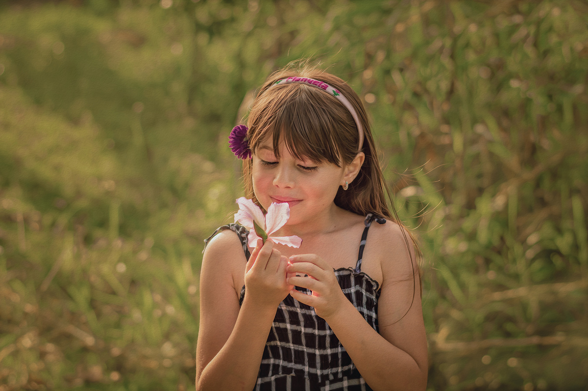 foto menina segurando uma flor