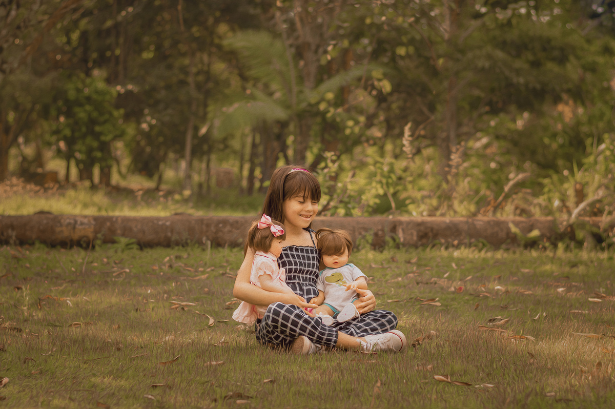 Foto menina rindo brincando com bonecas