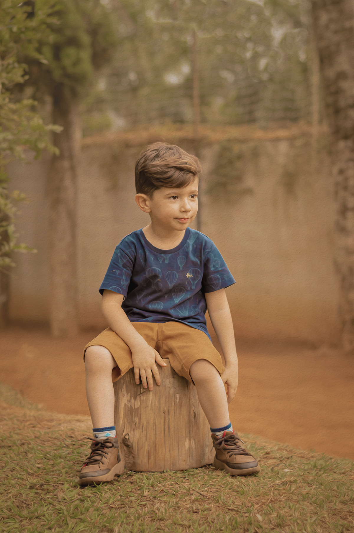 foto menino sentando sorrindo olhando para o lado