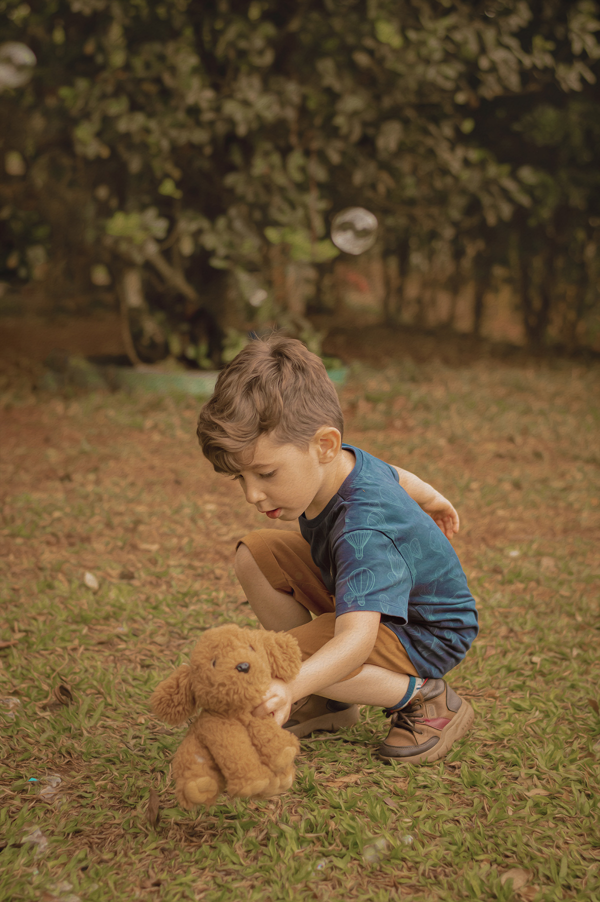 foto menino pegando ursinho no chão