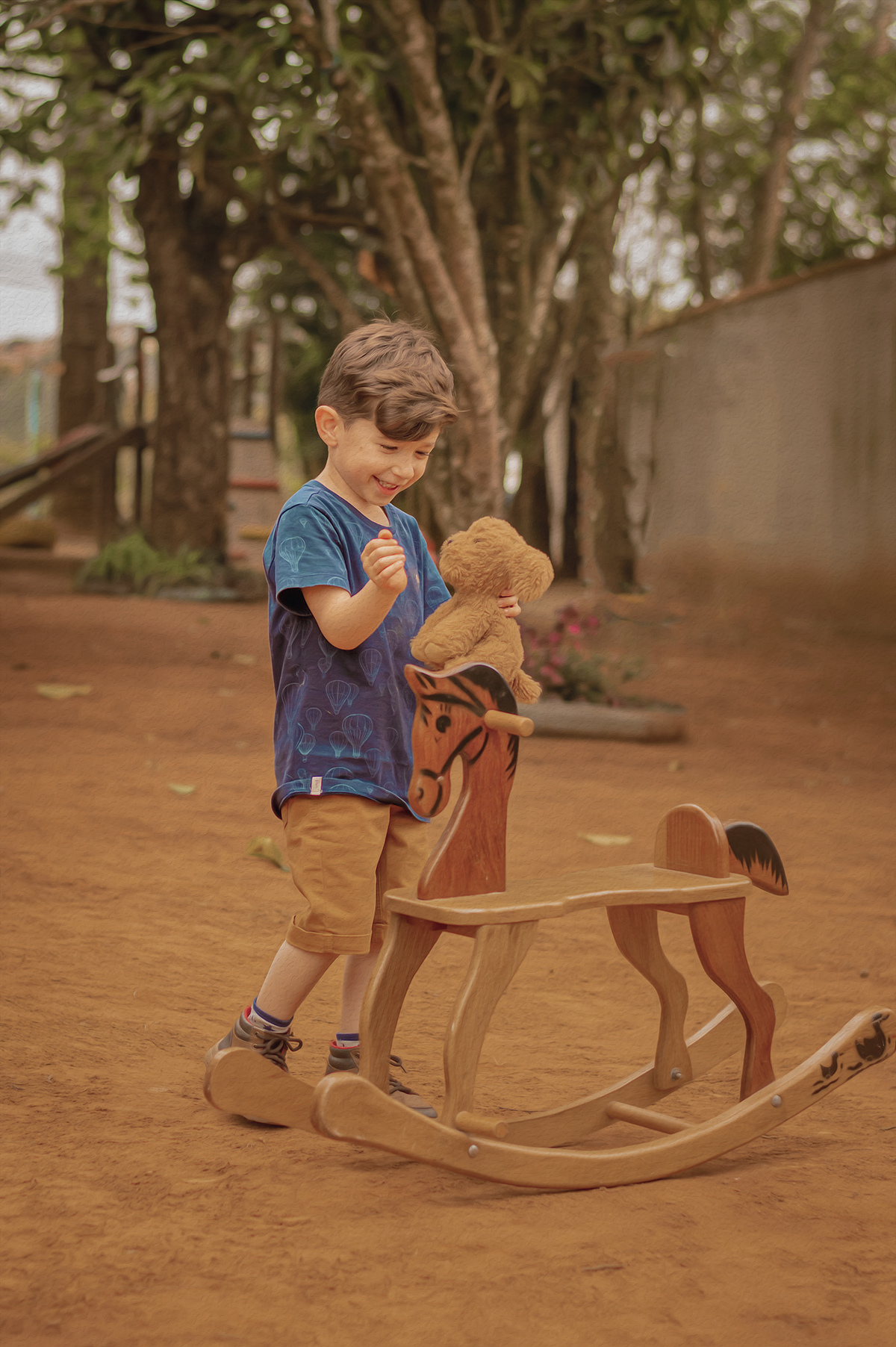 Foto menino, cavalinho de madeira e cachorro de pelúcia