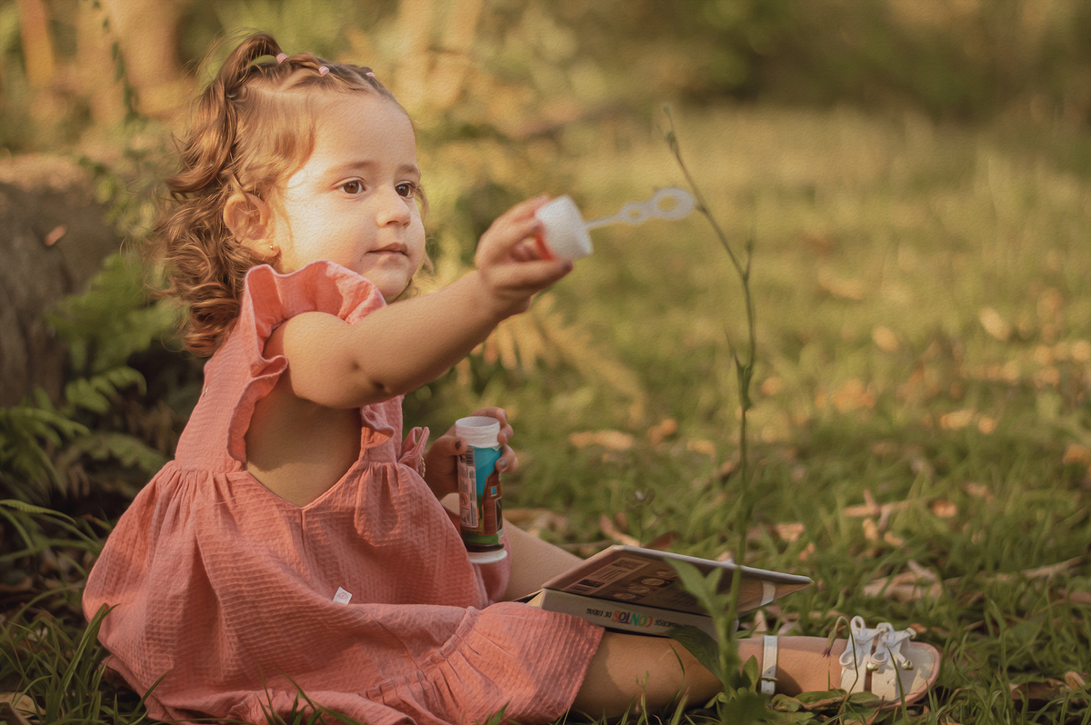 foto menina na natureza segurando brinquedo de bolhas de sabão